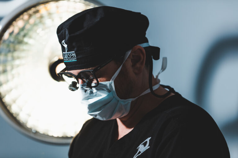 Plastic surgeon wearing protective mask and glasses performs labiaplasty near Catalina Foothills